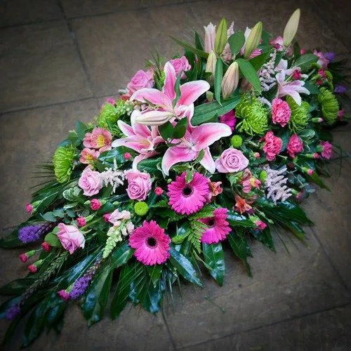 Composition florale de deuil en fleurs fraîches avec lys et gerberas roses