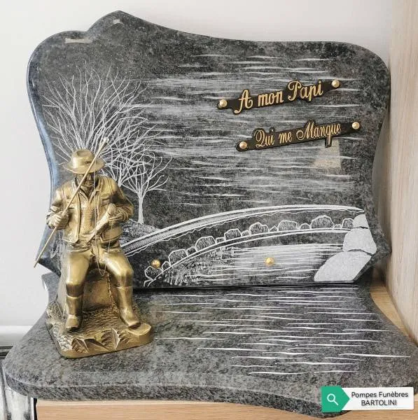 Plaque funéraire en granit avec figurine de pêcheur assis sur un pont
