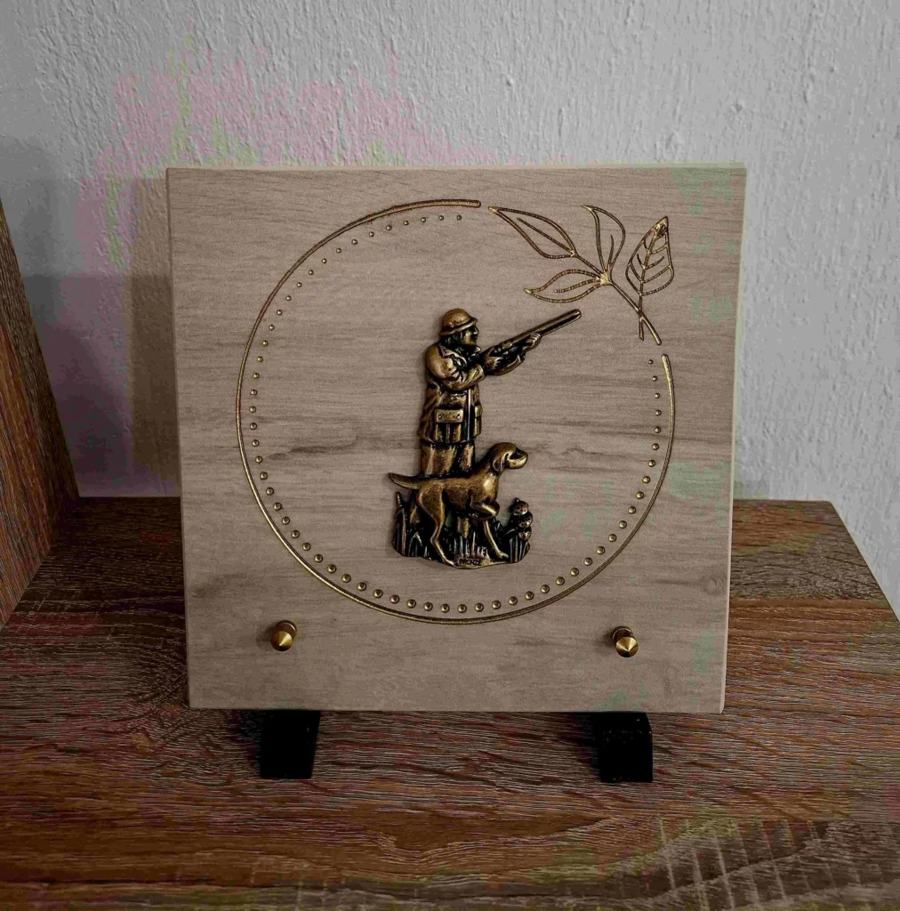 Plaque funéraire en céramique beige avec médaille en bronze de chasseur et son chien