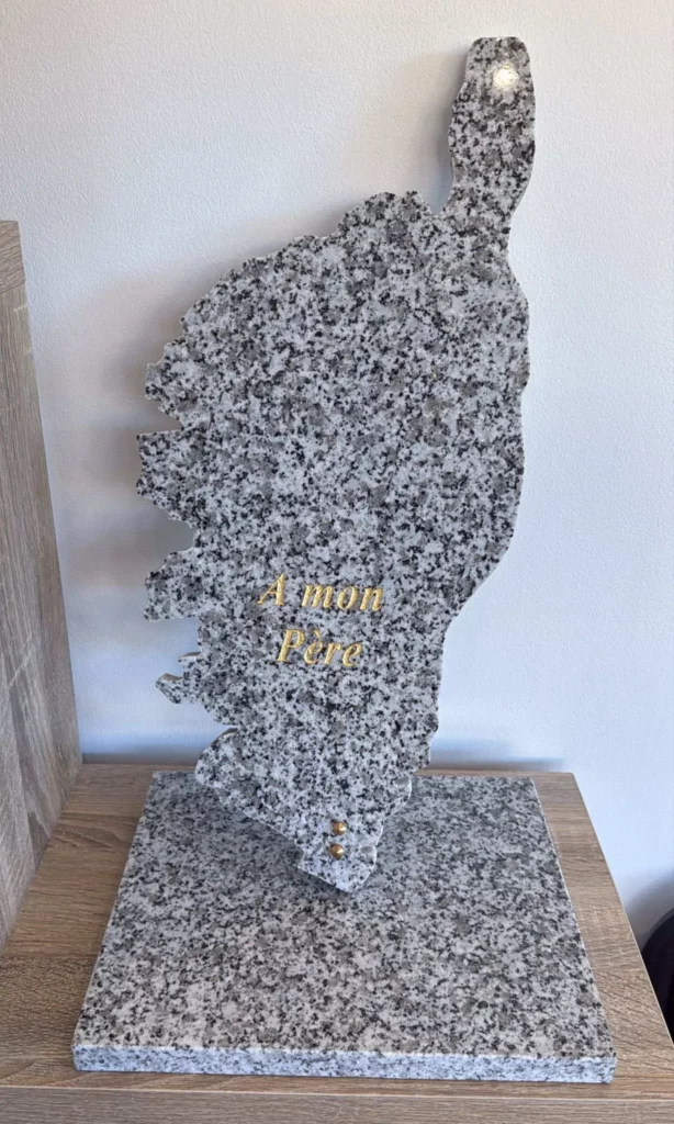Plaque funéraire découpée en forme de carte de la Corse en granit gris