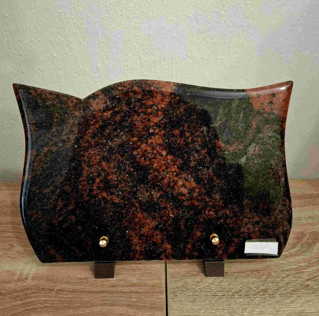 Plaque funéraire en granit multicolore rouge et noir forme Aurora à bords ondulés