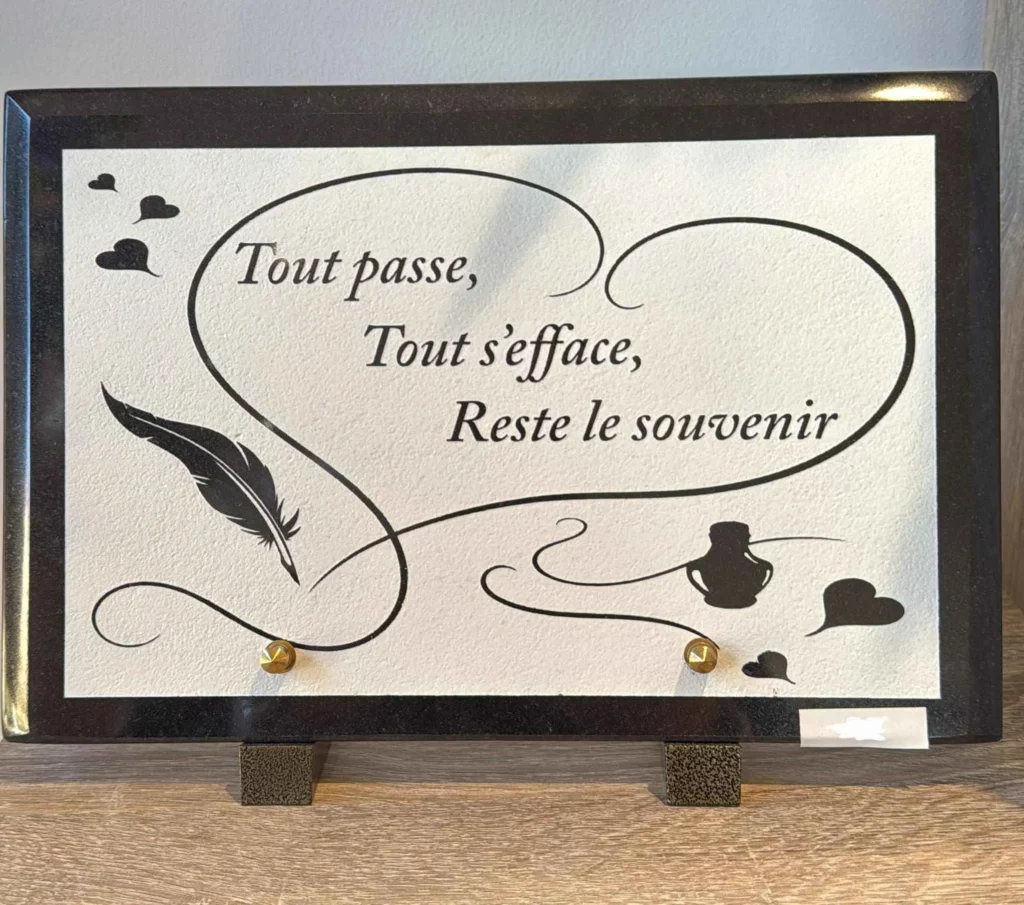 Plaque funéraire en granit avec parchemin gravé d'un cœur, d'une plume et texte poétique