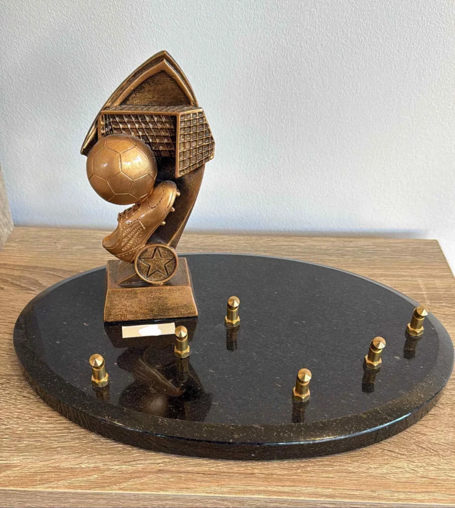 Plaque funéraire sur socle avec sculpture de ballon de football, chaussure et cage