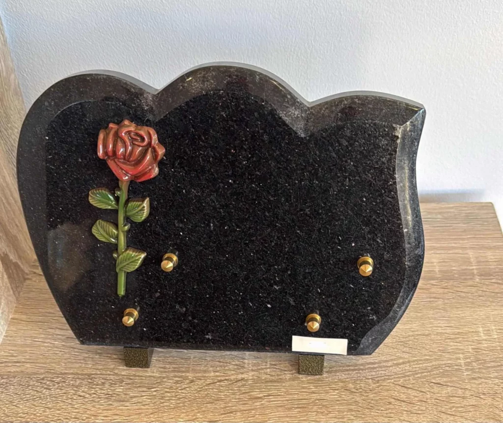 Plaque funéraire en granit noir forme nuage décorée d'une rose en bronze rouge