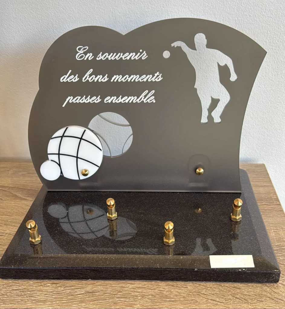 Plaque funéraire en plexiglas et granit illustrée d'un joueur de pétanque et boules