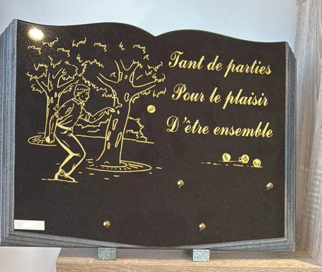 Plaque funéraire en granit forme livre gravée de boulistes jouant sous les arbres
