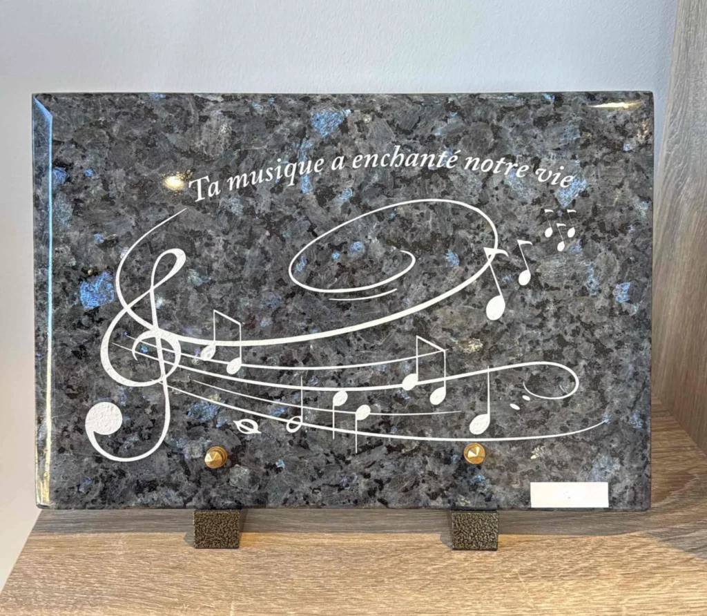 Plaque funéraire en granit bleu gravée d'une portée musicale avec clé de sol