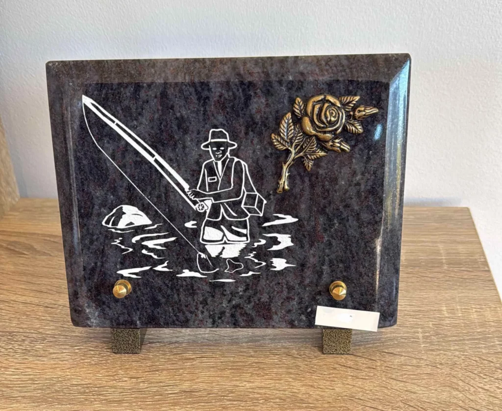 Plaque funéraire en granit gravée d'un pêcheur à la ligne avec rose en bronze