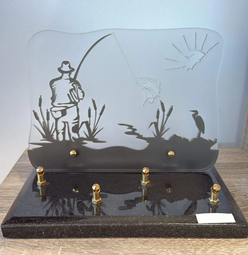 Plaque funéraire en plexiglas représentant un pêcheur au bord d'un marécage