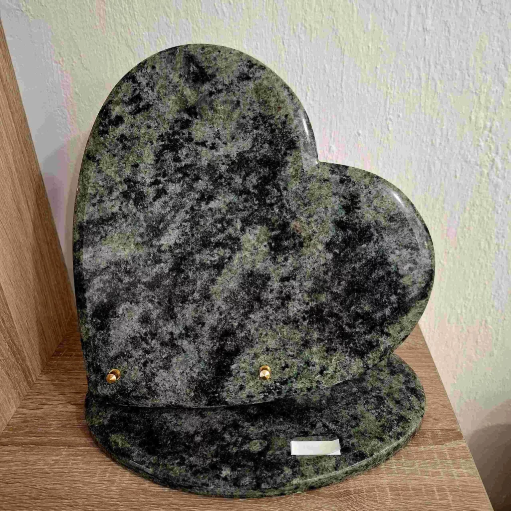 Plaque funéraire en granit vert découpée en forme de cœur sur socle