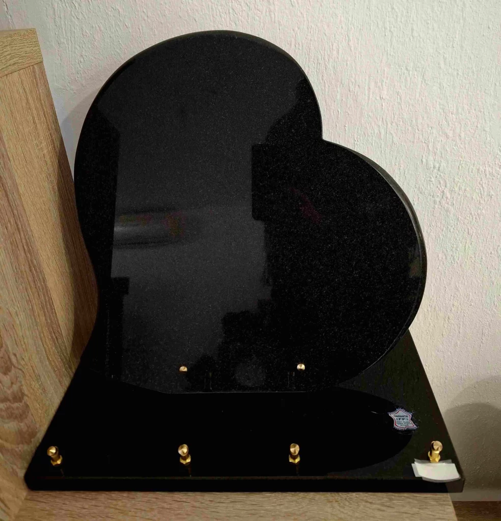 Plaque funéraire en granit noir fin découpée en forme de cœur sur socle