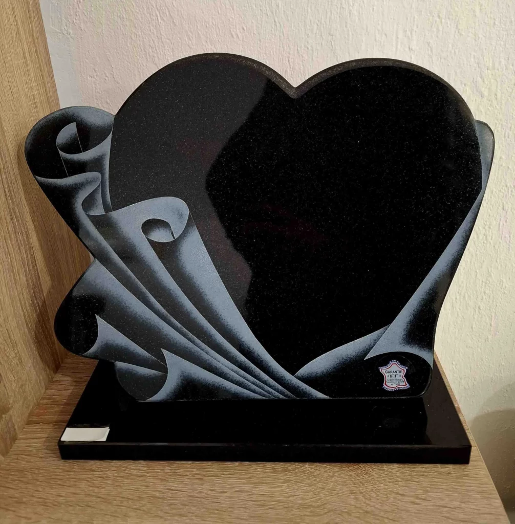 Plaque funéraire cœur en granit noir entourée d'un drapé sculpté