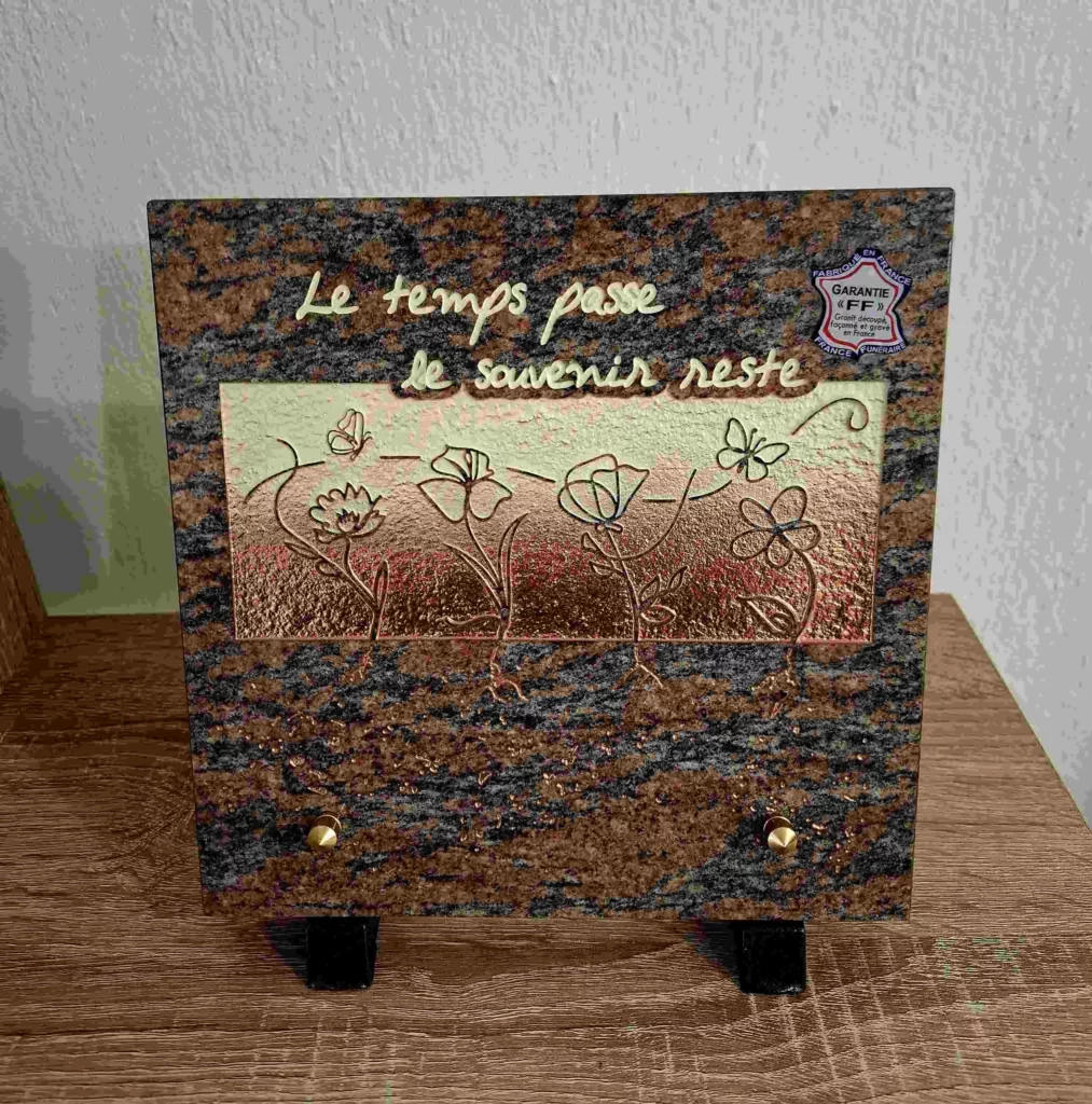 Plaque funéraire en granit rose veiné gravée de papillons et fleurs des champs