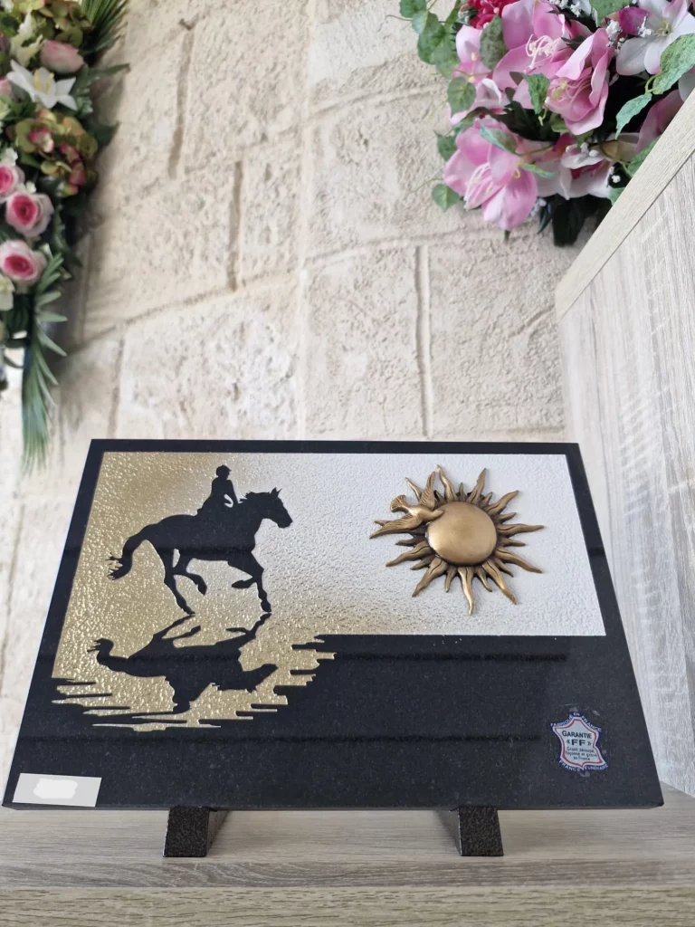 Plaque funéraire en granit noir motif cavalier à cheval et soleil radiant en bronze