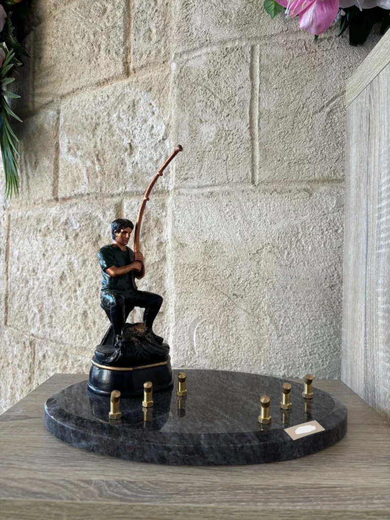 Plaque funéraire avec figurine 3D de pêcheur assis avec sa canne à pêche