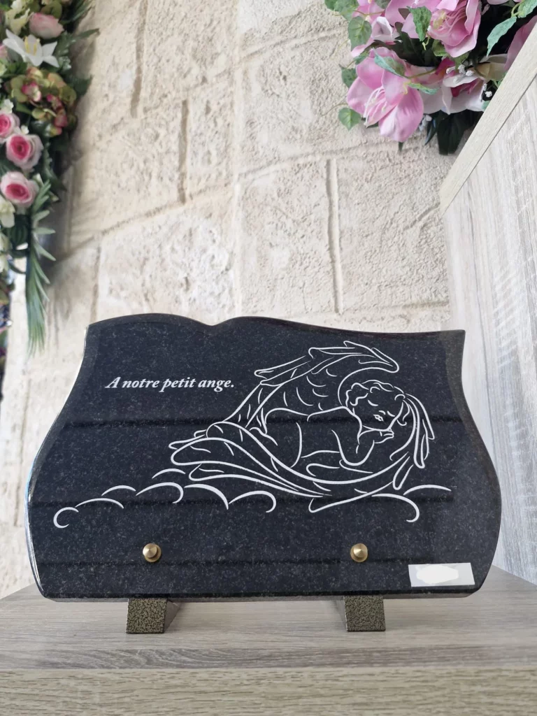 Plaque funéraire rectangulaire en granit avec gravure d'un petit ange endormi