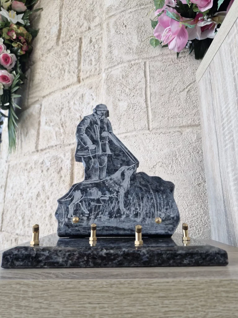 Plaque funéraire en granit sculpté motif chasseur accompagné de son chien