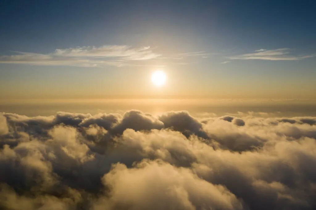 Paysage céleste au-dessus des nuages éclairé par un soleil couchant