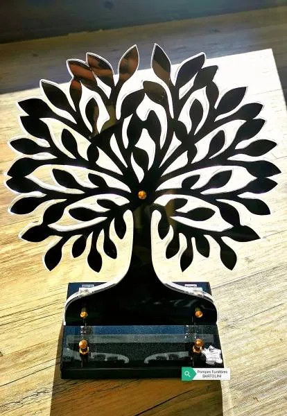 Plaque funéraire moderne en forme d'arbre de vie découpé posée sur un socle